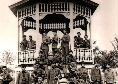 1904 black and white photo of all-male Native band posing with their instruments at a gazebo